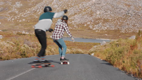 young friends longboarding together riding downhill enjoying skating fast doing tricks using skateboard on countryside road happy teenagers wearing protective helmet