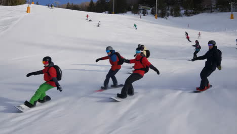 group snowboarding and skiing down a snowy mountain slope