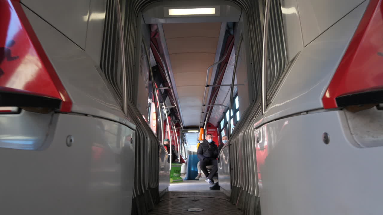 Passengers With Face Masks Sitting in Almost Empty Tram During Covid-19 Outbreak in Prague, Czech Republic. Low Angle Slow Motion