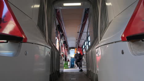 passengers with face masks sitting in almost empty tram during covid-19 outbreak in prague, czech republic. low angle slow motion