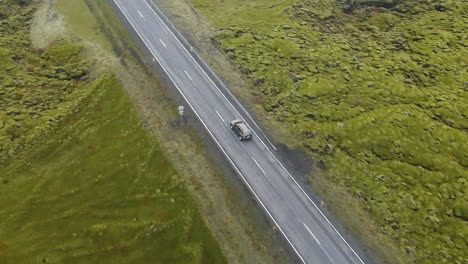 Luftaufnahme-Des-Autos,-Das-Entlang-Einer-Straße-Ins-Nirgendwo-In-Einer-Isländischen-Landschaft-Fährt