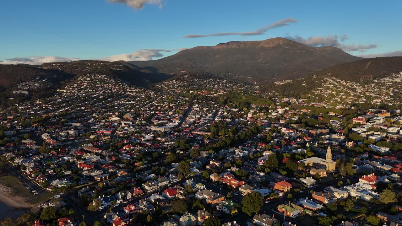 4K60 Aerial establishing shot of Hobart City with pier and harbor, Tasmania. Port with cityscape in Australia. Wide shot.