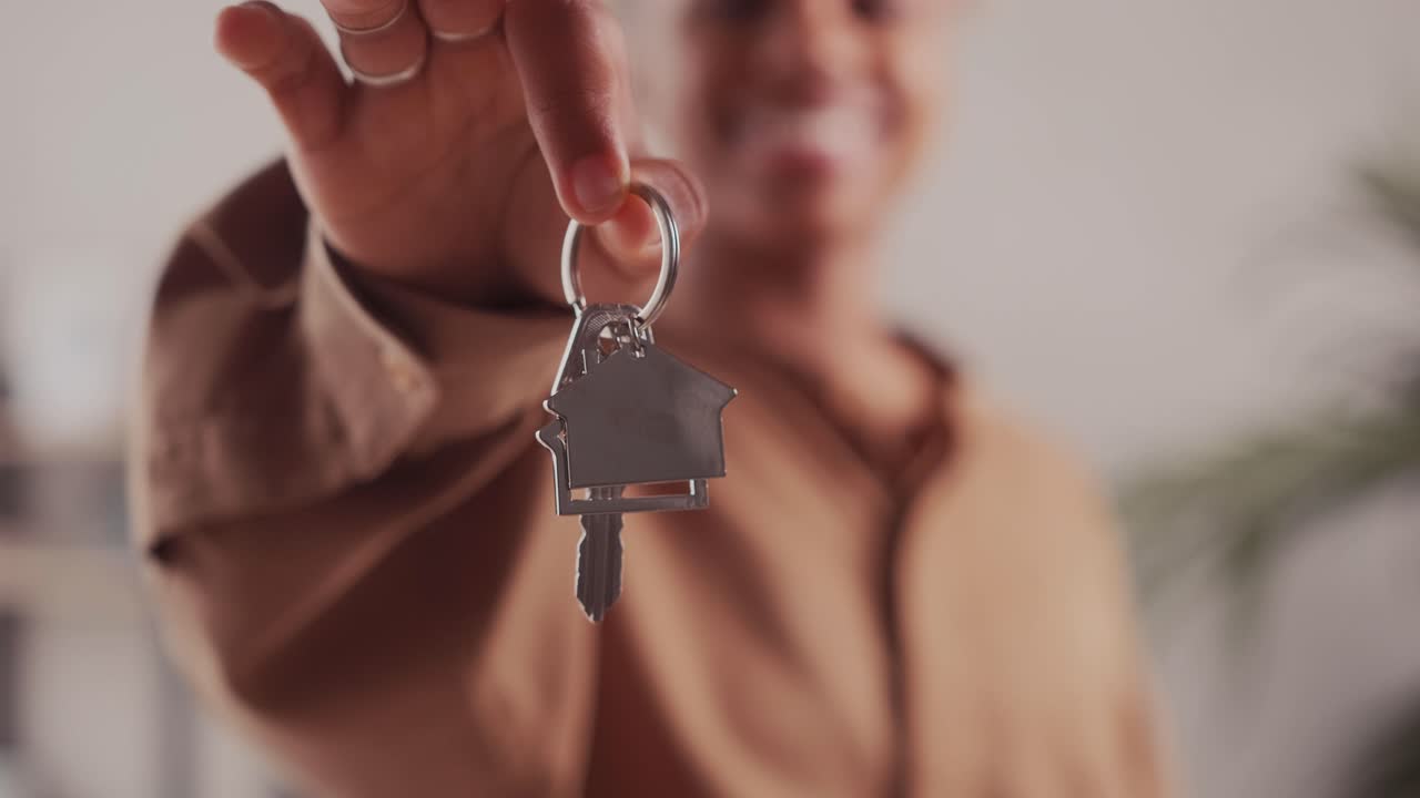 Happy african american woman holding keys close up focus on hand
