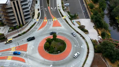 Hyperlapse-drone-shot-circling-a-urban-roundabout-full-of-traffic,-in-cloudy-USA