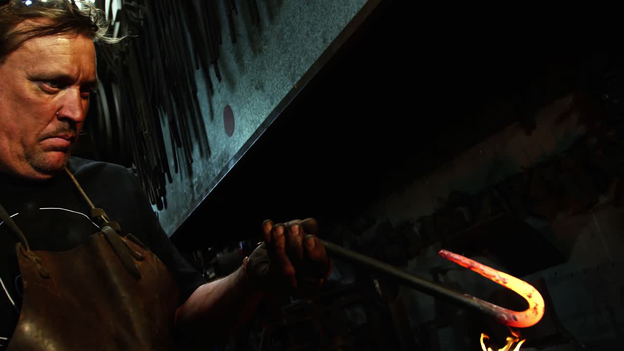 Blacksmith examining a iron rod