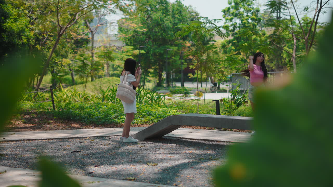 公園で屋外の写真を撮る2人の若い女性
