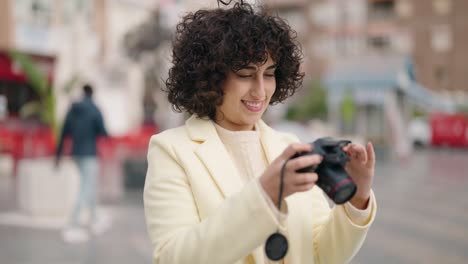 young woman smiling confident using professional camera at street