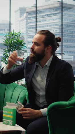 vertical video concerned ceo taking an aspirin to ease the headache due to stress