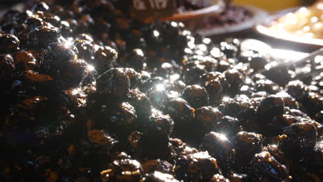 black olives on a stall close up sun reflection local french vegetable market