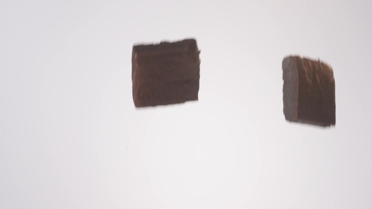 濃厚なファッジブラウニーが白い背景でフレームを流れ落ちるようにゆっくりと落下する。チョコレートブランドのコマーシャル、贅沢なデザートリール、心安らぐ食べ物の投稿