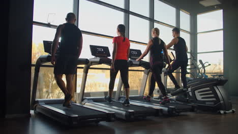 young men men and women walking on treadmills in the gym in slow motion.