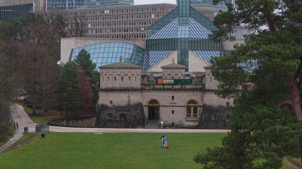 Drone footage revealing Poterne Couverte in Luxembourg’s urban park, showcasing historic fortifications amid scenic greenery and city landscape.