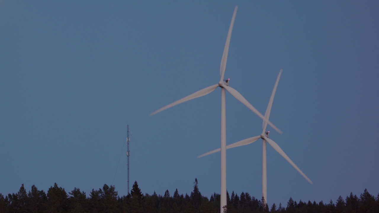 TWILIGHT, CLOSEUP, ZOOM IN - Wind turbines spin fast next to a full moon