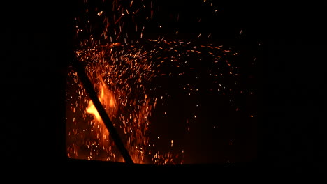 Hombre-Moviendo-La-Madera-De-La-Chimenea,-Partículas-De-Fuego