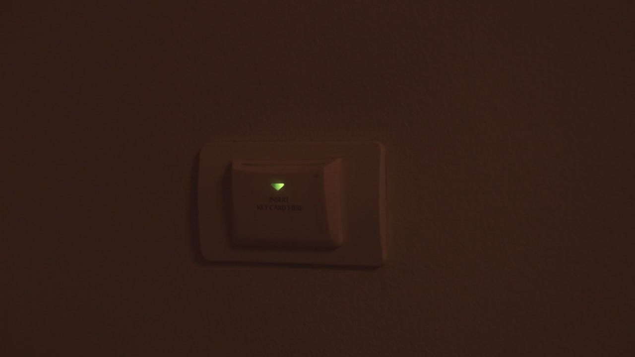 la mano de un hombre inserta una tarjeta de proximidad para abrir el poder en el hotel.