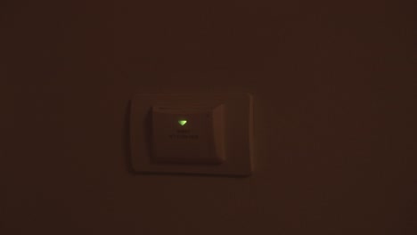 la mano de un hombre inserta una tarjeta de proximidad para abrir el poder en el hotel.