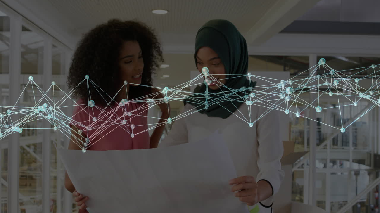 Reviewing plans with network connections animation, two women collaborating in office