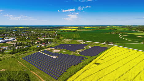 hyperlapse drone view over solar farm and vivid crop fields under clear blue sky
