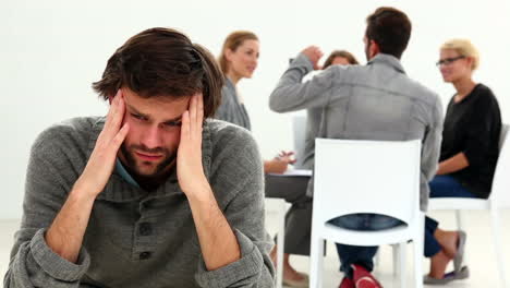 rehab group sitting in a circle with one man excluded