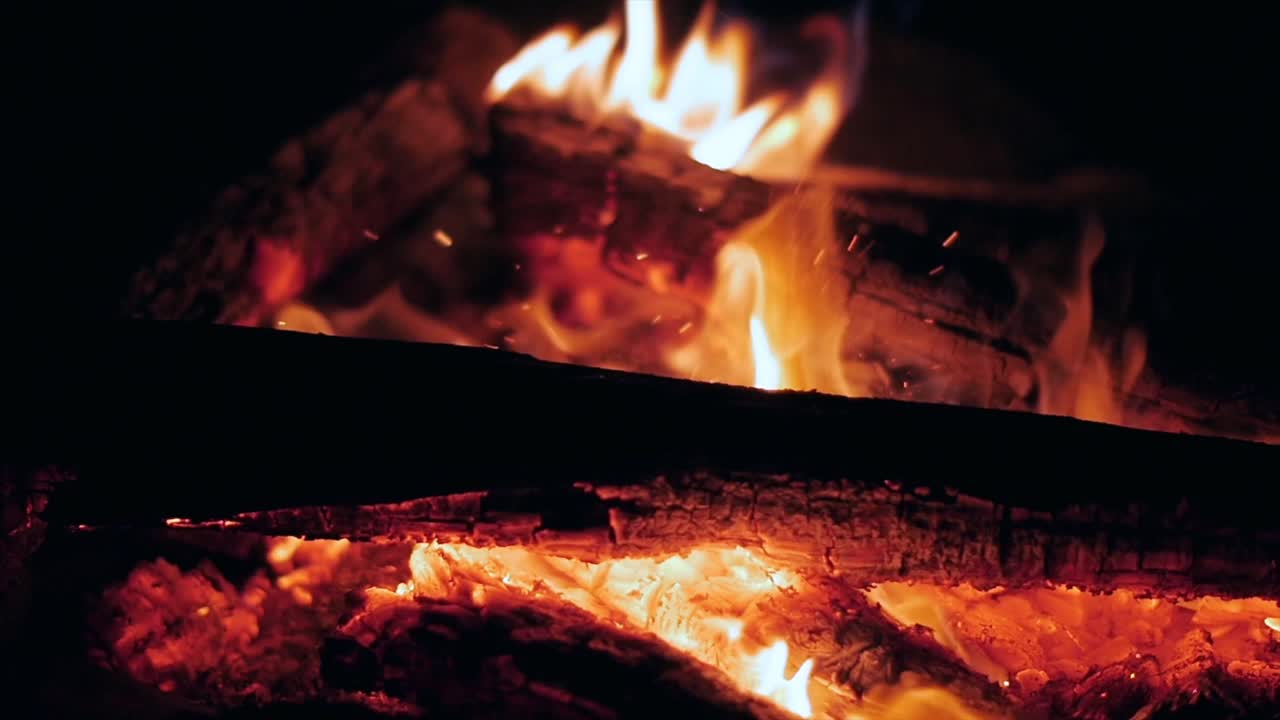 주위를 날아다니는 멋진 불꽃과 함께 슬로우 모션으로 모닥불의 불꽃