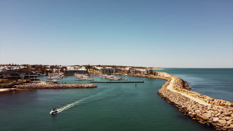 Flying-over-yachts-and-sailboats-anchored-with-a-coastal-home-nearby