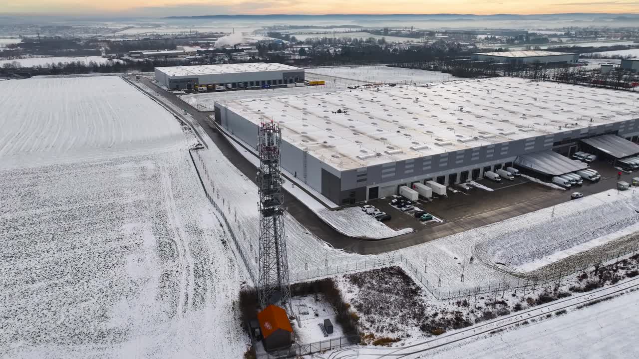 Aerial - large distribution center with loading docks in winter, Czechia
