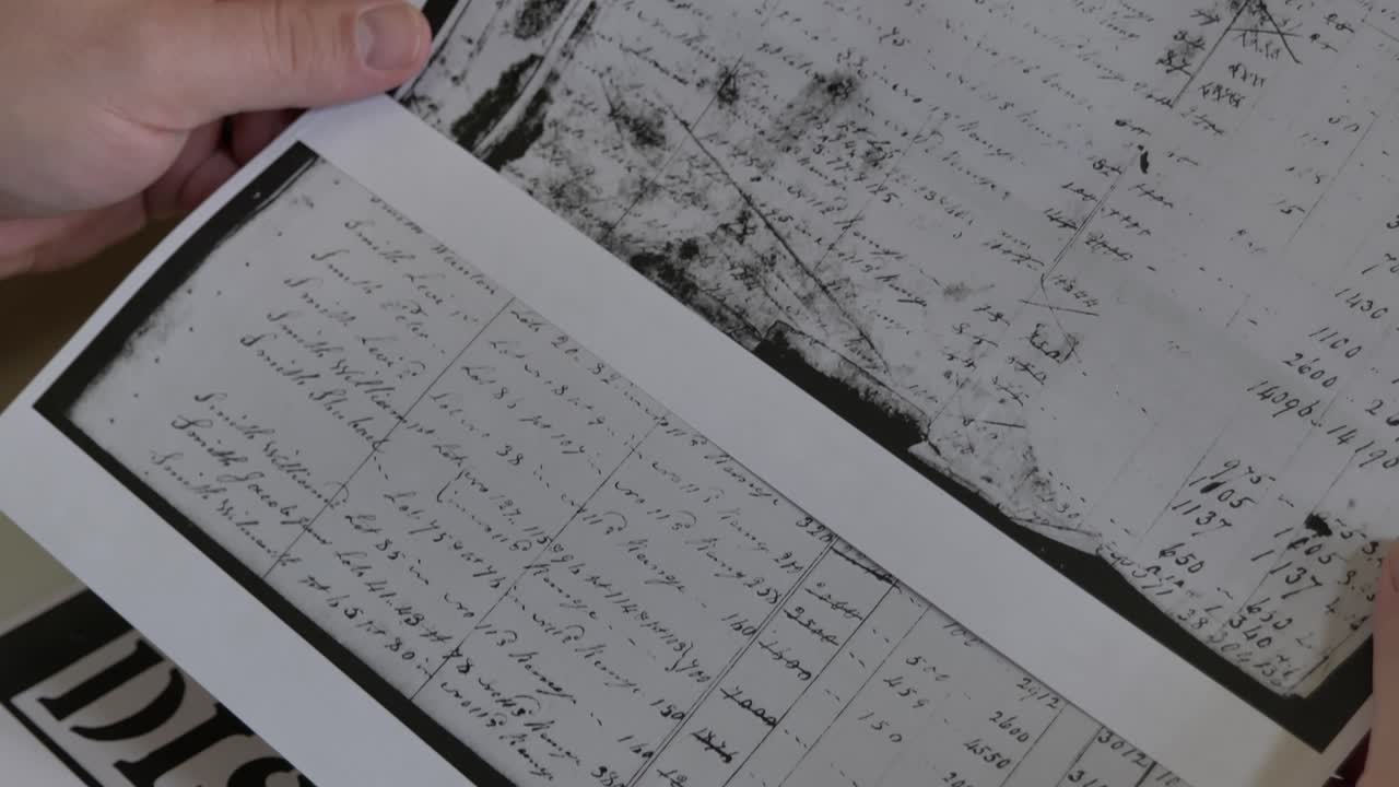 뉴욕 캐넌다이과에 있는 온타리오 카운티 연구회를 위한 1800년대 초기 미국의 고대 세금 서류를 살펴보고 있는 역사 박물관 및 연구 도서관