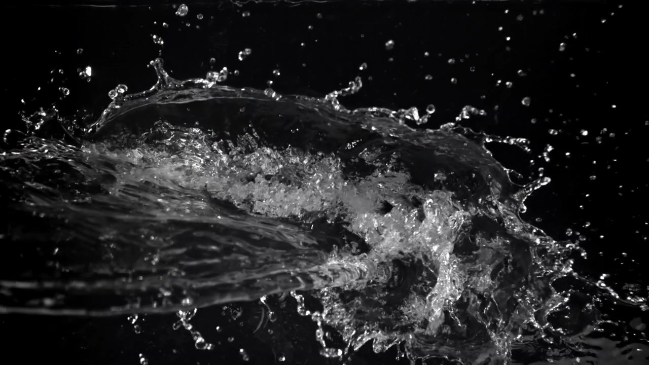 Hældende og plaskende vand i slowmotion på sort baggrund