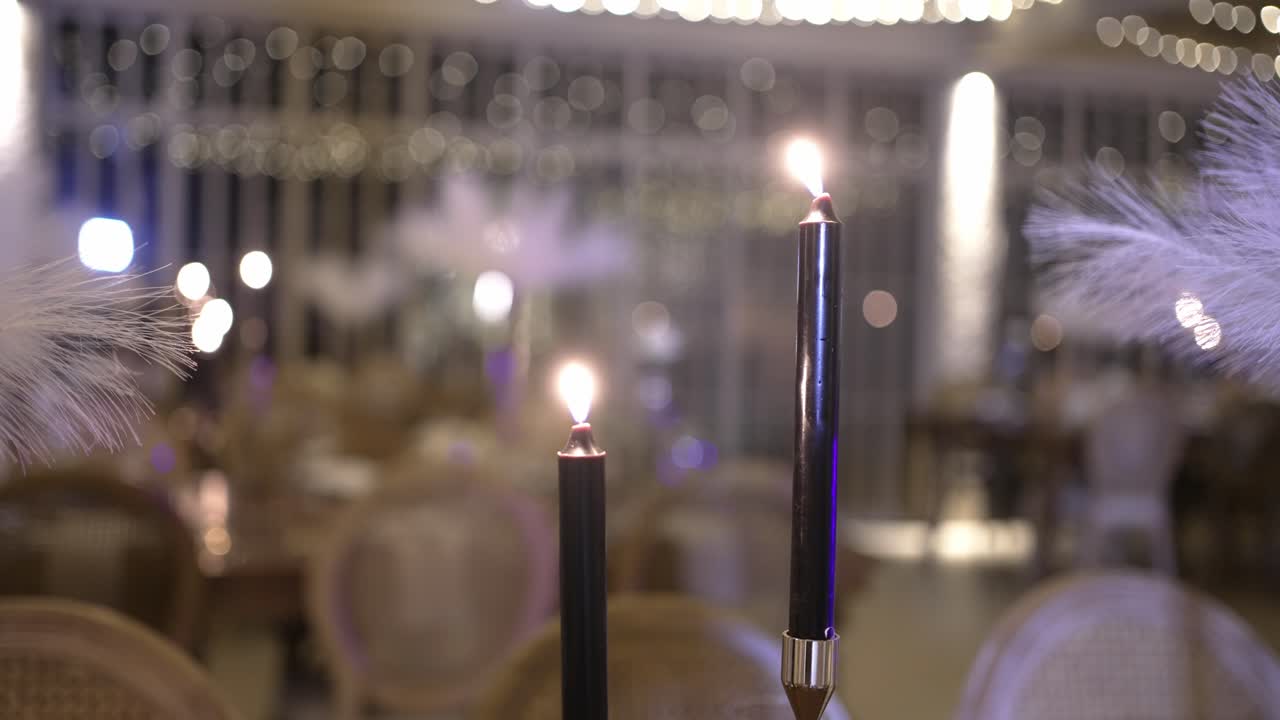 black candles burning in elegant wedding banquet room at night