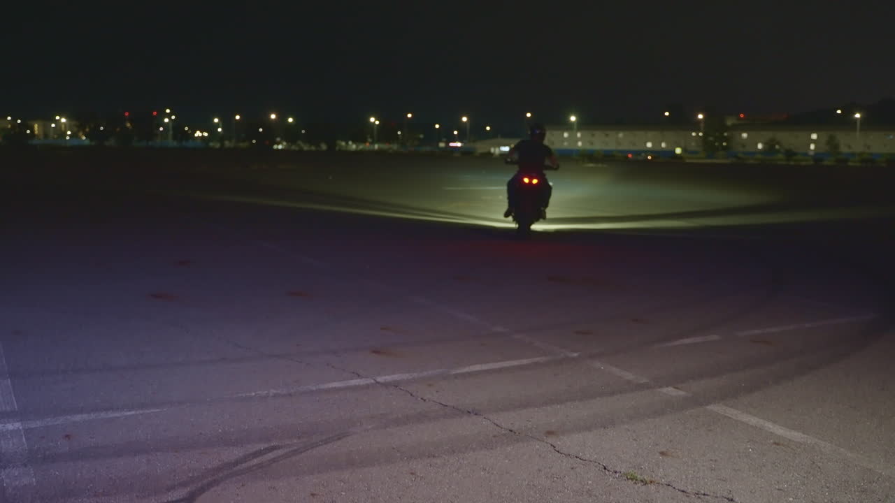 Motorcycle Stunt at Night in Parking Lot