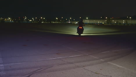 motorcycle stunt at night in parking lot