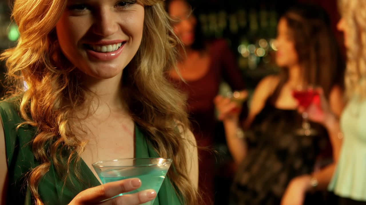 bella donna che beve un cocktail con gli amici