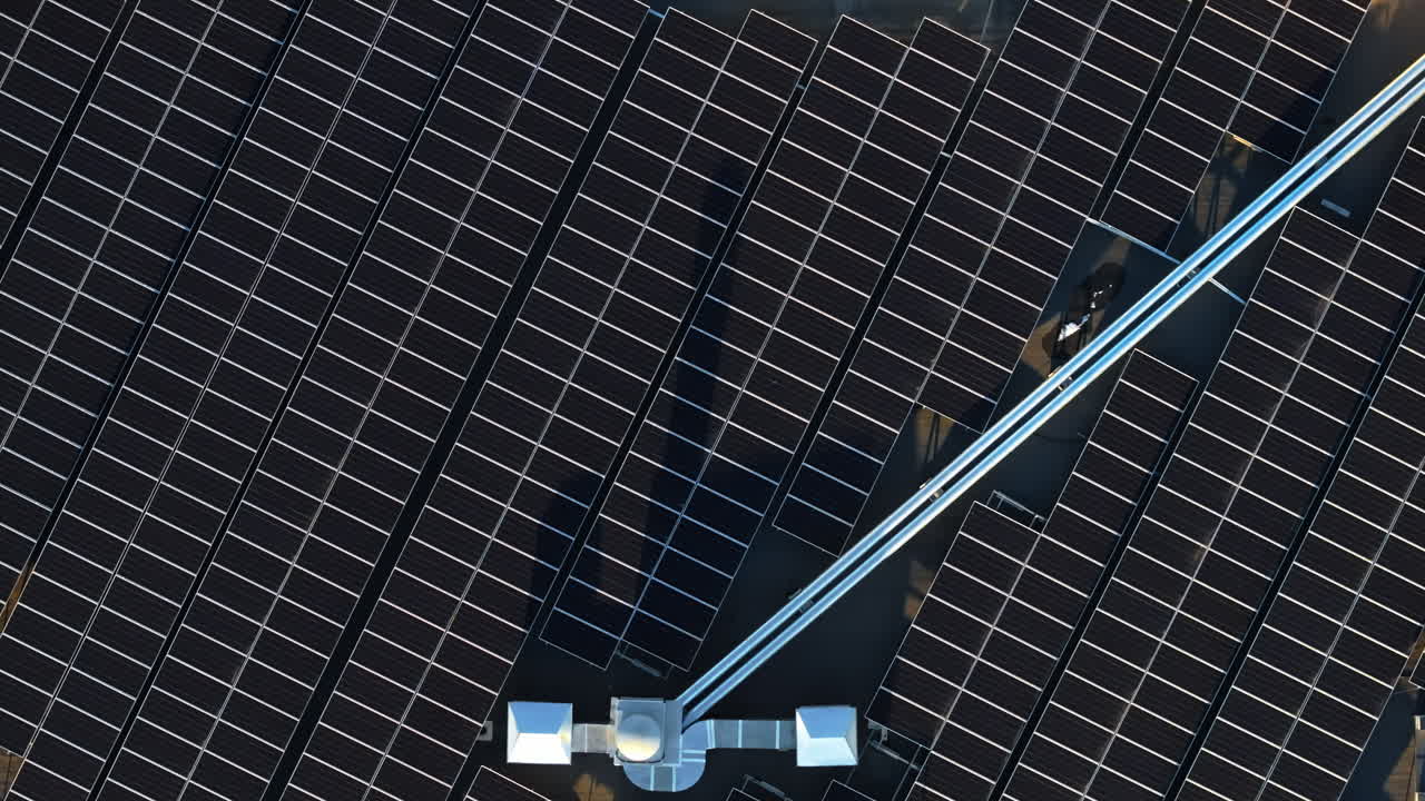Vista aerea di pannelli solari al tramonto ripresa da un drone. Pannelli fotovoltaici sul tetto dell'edificio. Fonte di energia alternativa. Concetto di risorse sostenibili