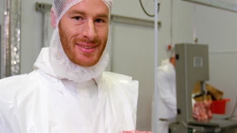 Portrait-of-butcher-holding-red-meat