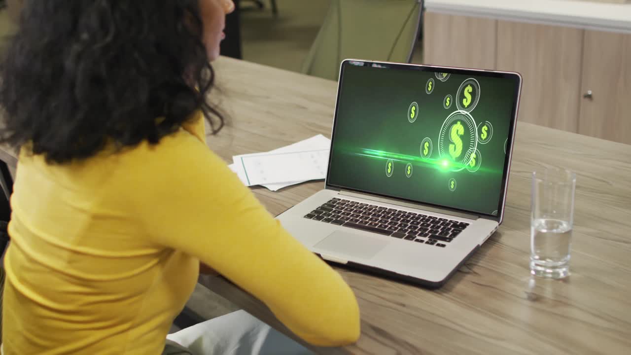 video de una mujer afroamericana trabajando en una computadora portátil con dólares en la pantalla