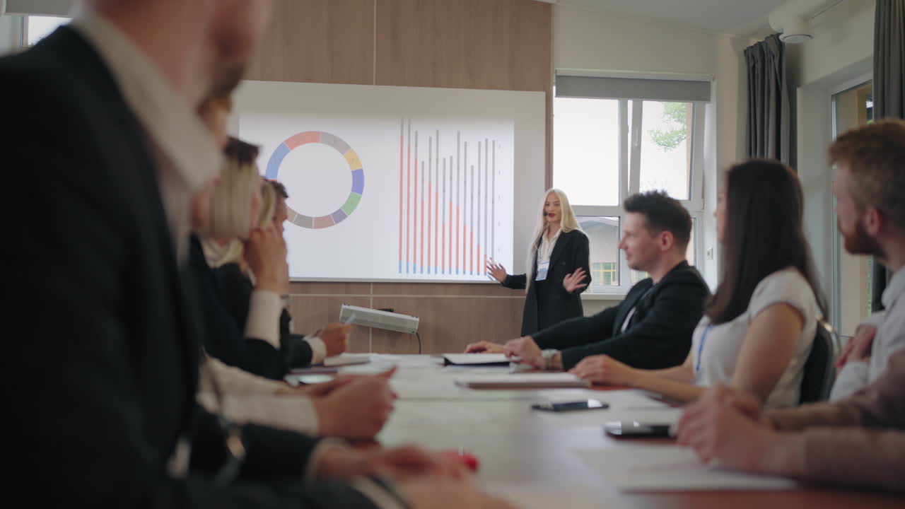 경제학자들과 금융 분석가들이 포럼이나 세미나에서 배우고 있습니다. 여성 전문가가 강연을 하고 있습니다.