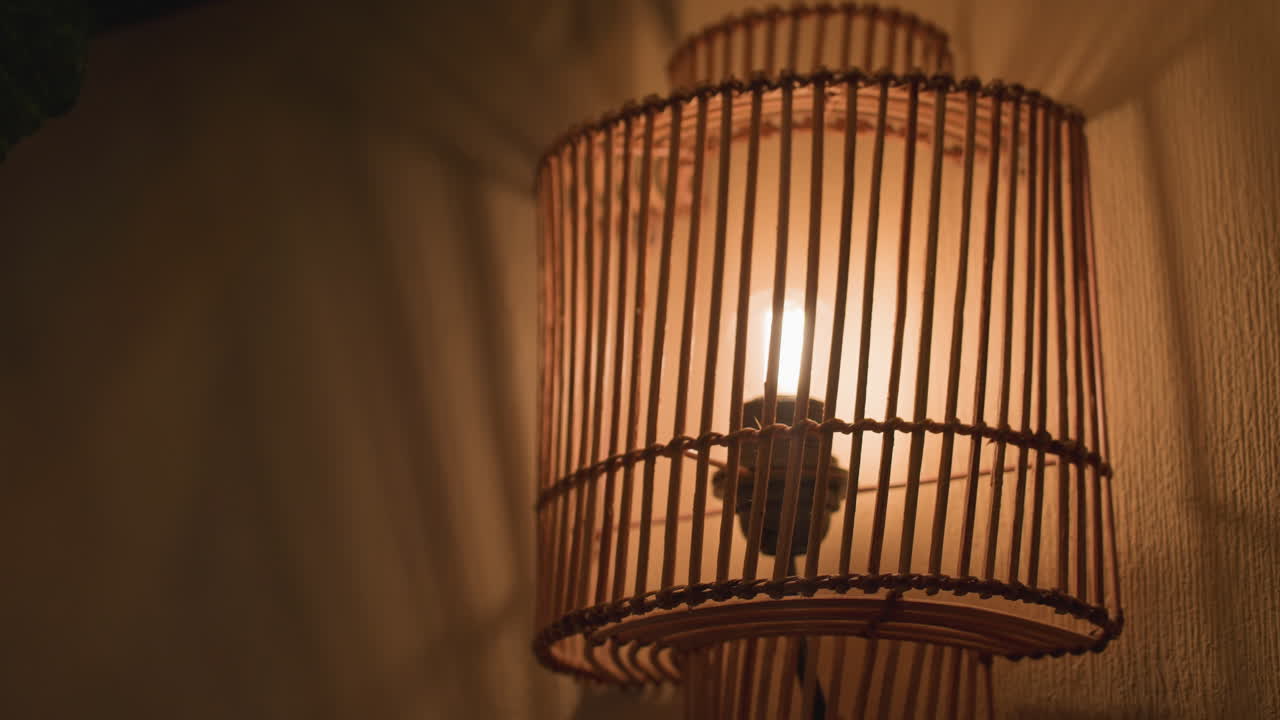 close up of warm glowing decorative wall light with wooden frame, mounted on textured wall, casting ambient light in cozy indoor setting, creating inviting and relaxing atmosphere