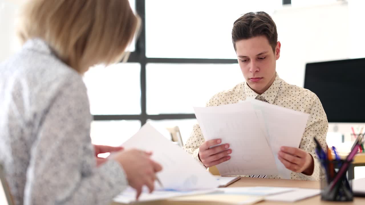 Due professionisti che esaminano documenti in un ufficio.