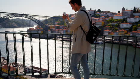 man taking photo of porto city from bridge