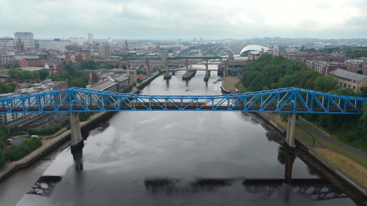 Vista aerea del Ponte Queen Elizabeth II che trasporta il treno della Tyne and Wear Metro attraverso il fiume Tyne a Newcastle, Inghilterra, con lo skyline della città e i ponti