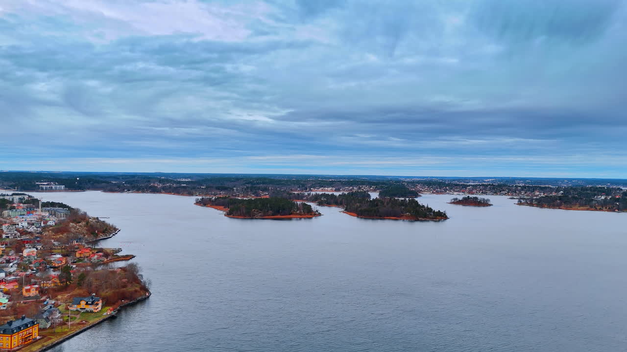Veduta aerea panoramica di piccole isole nel Mar Baltico. Inquadratura dall'alto che mostra numerose isole boscose e la costa dell'arcipelago di Stoccolma sotto un cielo nuvoloso.