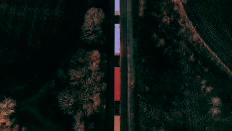 Aerial-birdseye-over-long-stopped-freight-train-revealing-cloudless-blue-sky