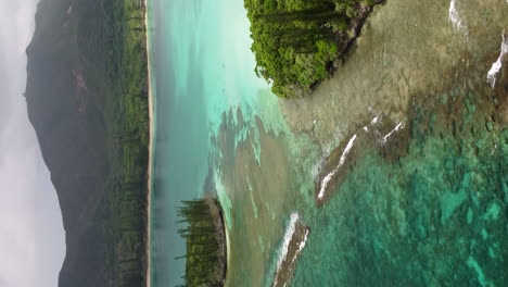 Aerial-arc-above-pristine-water-and-small-islands,-N'ga-peak-in-background,-Isle-of-pines