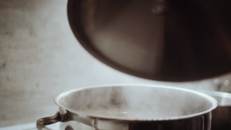 opening lid from pot of boiling soup to spice it with fresh herbs, close up