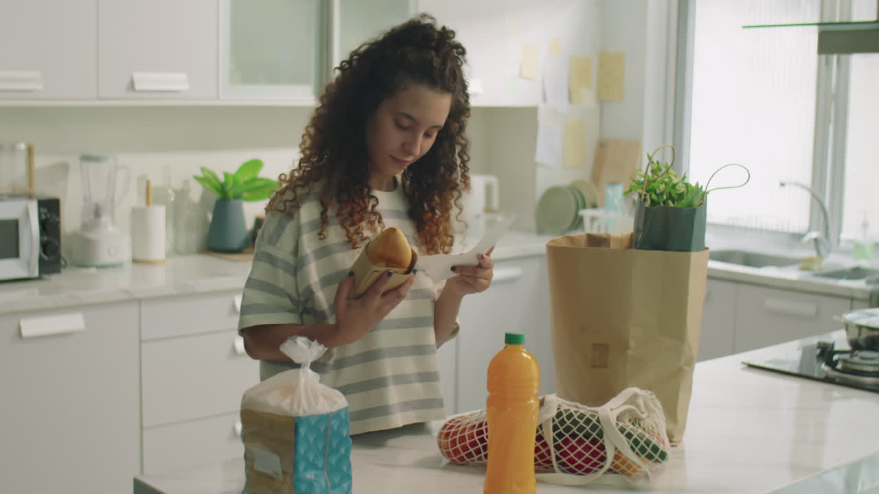 Girl Reading Receipt for Groceries from Supermarket