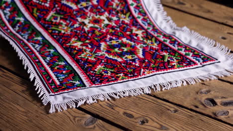 colorful embroidered tablecloth on wooden table