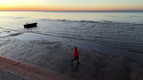 A-person-is-walking-on-the-beach-at-sunset