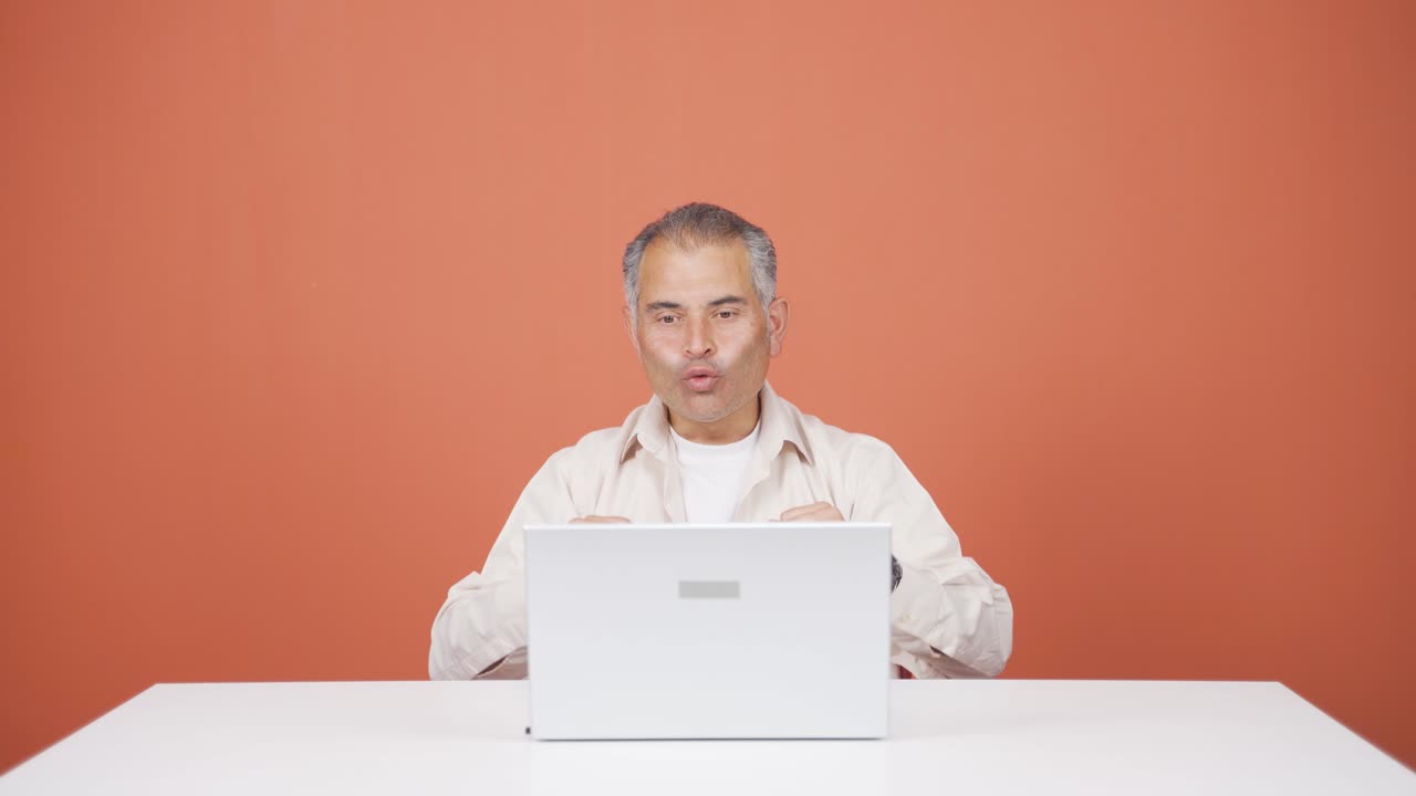 노트북을 보는 남자가 박수를 치고 있습니다.