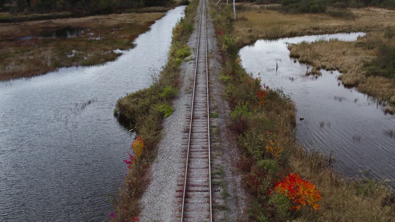 árboles de otoño por las vías del ferrocarril del río androscoggin, panorámica aérea revela