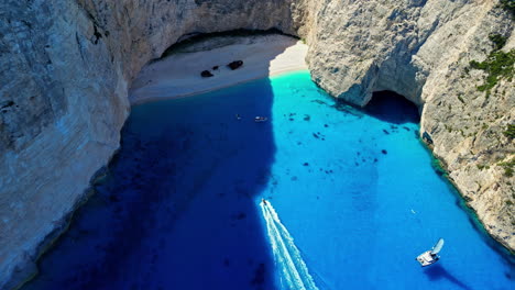 Drone-Aéreo-Tomado-De-Arriba-Hacia-Abajo-Sobre-Una-Playa-Cerrada-Famosamente-Llamada-La-Bahía-Del-Naufragio-En-La-Isla-De-Zakynthos,-Grecia-En-Un-Día-Soleado